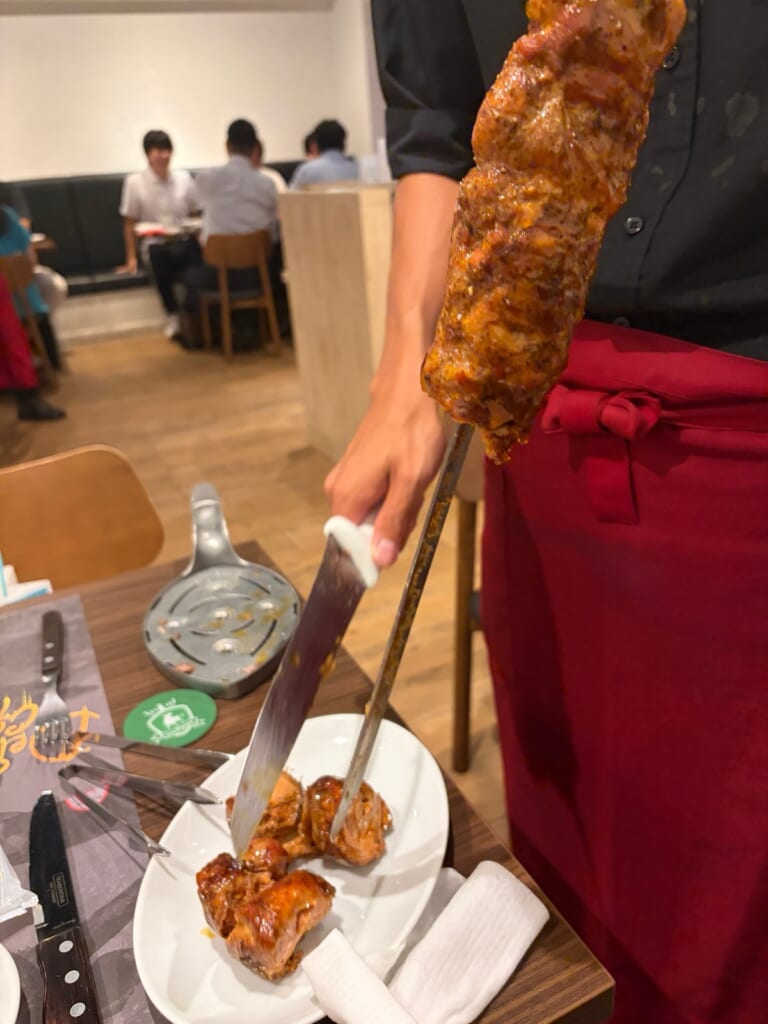 アレグリア千葉のシュラスコを店員さんが席で切り分けるところ